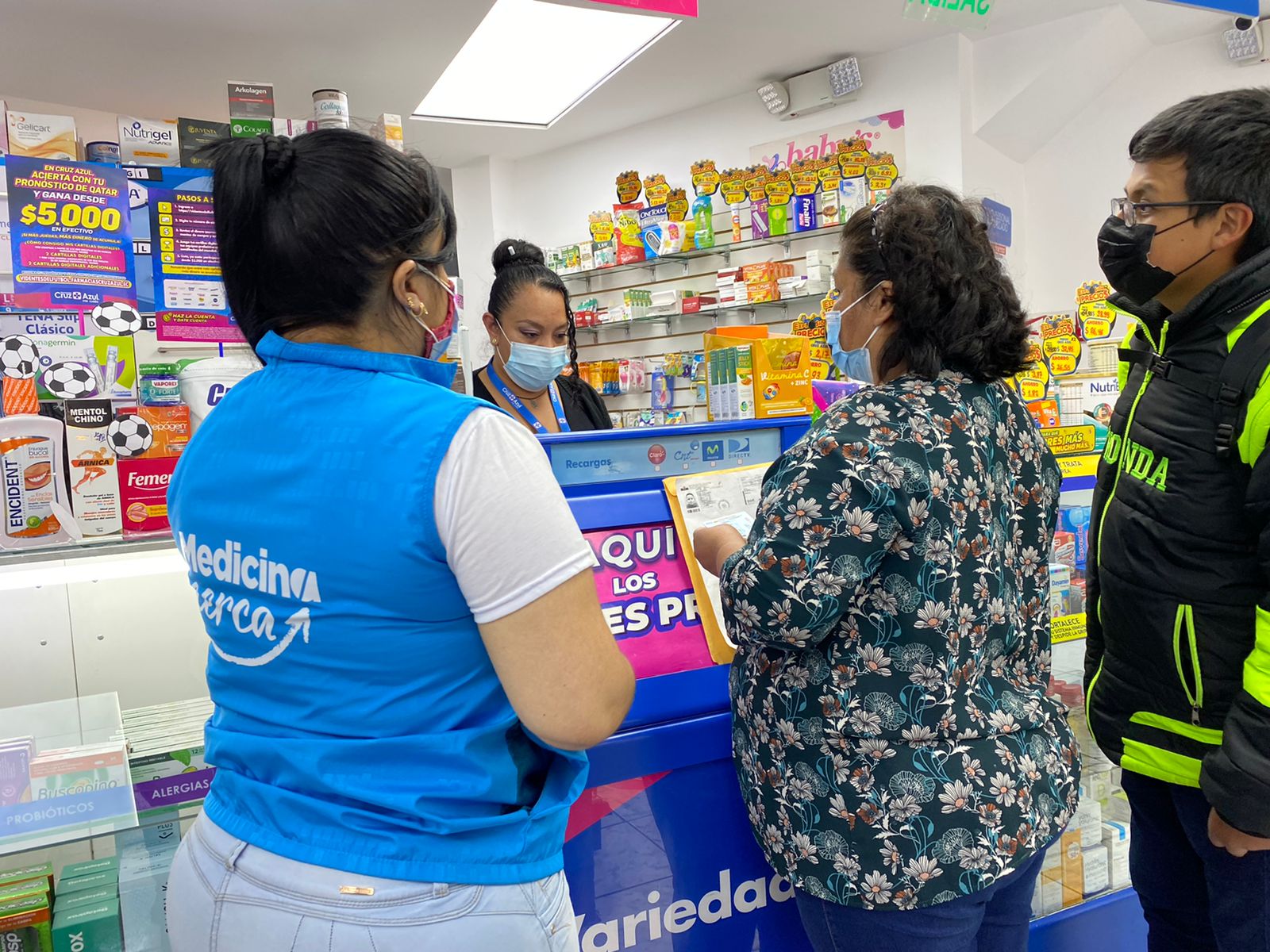 Mujer se encuentra en una farmacia junto a otras personas